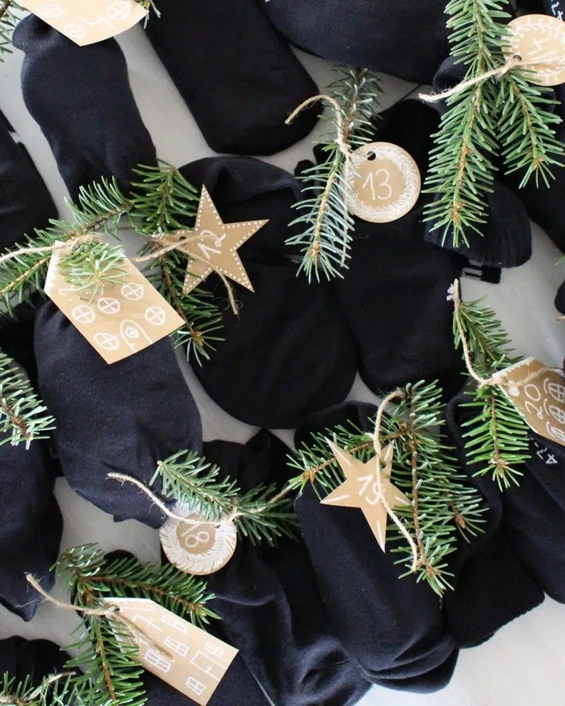 Du möchtest dieses Jahr einen DIY Adventskalender verschenken? Ich habe eine schöne und zugleich praktische Idee für dich! Du kannst einfach 12 Paar Socken mit Kleinigkeiten befüllen. So sparst du dir das Verpackungsmaterial und die kleinen Geschenke sind super schnell verpackt. Zusätzlich habe ich kleine süße Anhänger für die Zahlen gebastelt und etwas Tannengrün an den kleinen Päckchen festgebunden. DIY Adventskalender aus Socken basteln | Tinkerhome - einfache DIYs für Zuhause