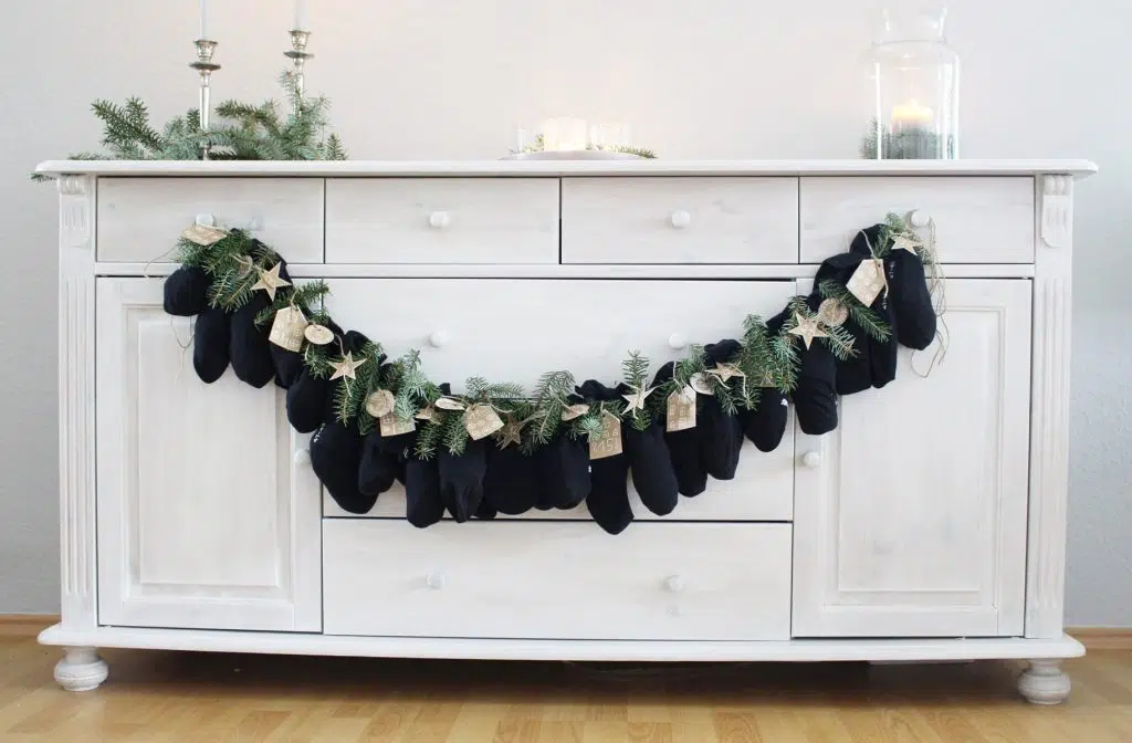 Du möchtest dieses Jahr einen DIY Adventskalender verschenken? Ich habe eine schöne und zugleich praktische Idee für dich! Du kannst einfach 12 Paar Socken mit Kleinigkeiten befüllen. So sparst du dir das Verpackungsmaterial und die kleinen Geschenke sind super schnell verpackt. Zusätzlich habe ich kleine süße Anhänger für die Zahlen gebastelt und etwas Tannengrün an den kleinen Päckchen festgebunden. DIY Adventskalender aus Socken basteln | Tinkerhome - einfache DIYs für Zuhause