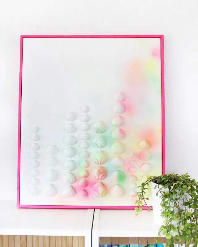 Sammelst du auch so gerne Muscheln? Damit diese nicht einfach in irgendeiner Kiste landen, habe ich ein DIY Bild mit Muscheln für meine Mama gebastelt. Dieses besteht aus Muscheln, die sie viele Jahre gesammelt hat. Das Tolle ist, dass man die Struktur der Muscheln auch nach dem Ansprühen noch erkennt und dadurch auch weiß, welche Muscheln wo gesammelt wurden. Das Bild wurde übrigens direkt zum Eyecatcher und ist allen sofort aufgefallen, obwohl es extra schlicht ist. Mittlerweile habe ich auch ein Muschelbild für uns gebastelt und dieses steht im Sommer bei uns im Wohnzimmer. Allerdings habe ich unser DIY Muschelbild spontan farblich anders gestaltet. Sommerliches DIY Bild mit Muscheln basteln - diy muschelbild neon 15