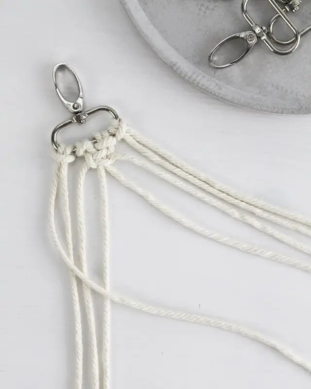 Makramee ist weiterhin im Trend und neben den klassischen Wandbehängen gibt es viele weitere Anwendungsmöglichkeiten. Im letzten Jahr habe ich mir sogar eine eigene Handtasche geknüpft. Vor ein paar Wochen bin ich nach Paris gereist und dafür brauchte ich eine kleine Umhängetasche, die ich gut vorne tragen kann. Parallel knüpfte ich an einem anderen Makrameeprojekt: einem Makramee-Übertopf mit dickerem Makrameegarn. Dabei kam mir die Idee, dass ein DIY Makramee Schultergurt aus diesem dicken Makrameegarn sicherlich toll aussähe. Also habe ich mich auf die Suche nach einer passenden Umhängetasche begeben, bei der ich den Schultergurt einfach abmachen kann, um später meinen eigenen Makramee Schultergurt daran zu befestigen. So kann man die Schultergurte beliebig wechseln. DIY Makramee Schultergurt knüpfen - 4 Anleitungen - diy makramee schultergurt handtasche knuepfen 13