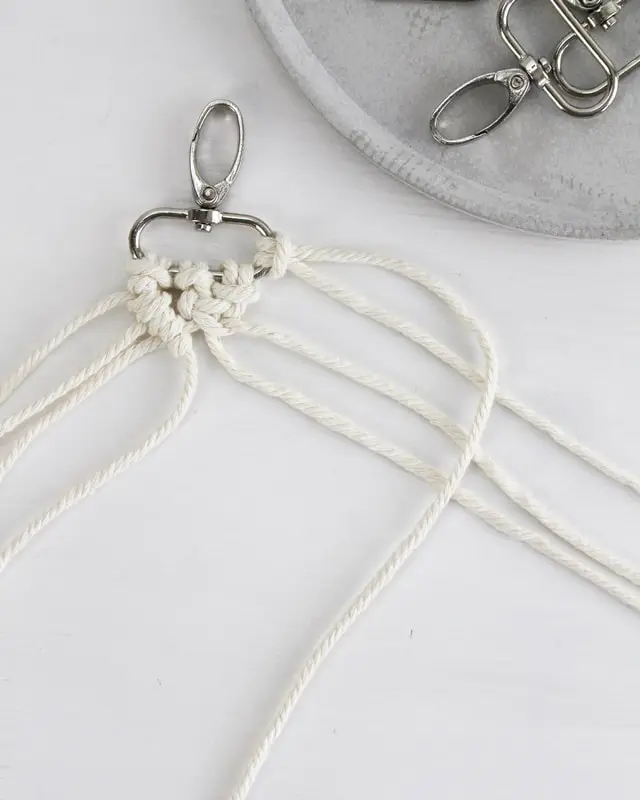 Makramee ist weiterhin im Trend und neben den klassischen Wandbehängen gibt es viele weitere Anwendungsmöglichkeiten. Im letzten Jahr habe ich mir sogar eine eigene Handtasche geknüpft. Vor ein paar Wochen bin ich nach Paris gereist und dafür brauchte ich eine kleine Umhängetasche, die ich gut vorne tragen kann. Parallel knüpfte ich an einem anderen Makrameeprojekt: einem Makramee-Übertopf mit dickerem Makrameegarn. Dabei kam mir die Idee, dass ein DIY Makramee Schultergurt aus diesem dicken Makrameegarn sicherlich toll aussähe. Also habe ich mich auf die Suche nach einer passenden Umhängetasche begeben, bei der ich den Schultergurt einfach abmachen kann, um später meinen eigenen Makramee Schultergurt daran zu befestigen. So kann man die Schultergurte beliebig wechseln. DIY Makramee Schultergurt knüpfen - 4 Anleitungen - diy makramee schultergurt handtasche knuepfen 23