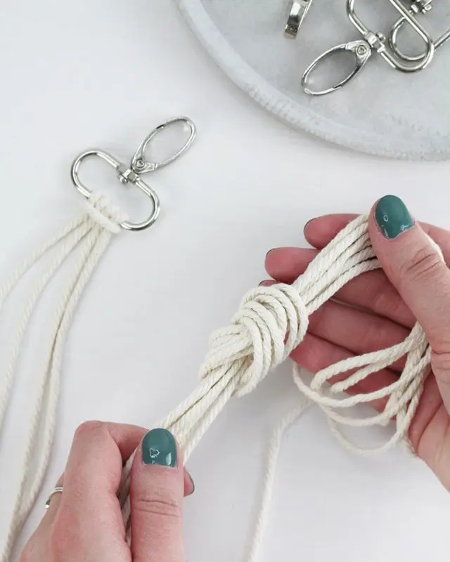 Makramee ist weiterhin im Trend und neben den klassischen Wandbehängen gibt es viele weitere Anwendungsmöglichkeiten. Im letzten Jahr habe ich mir sogar eine eigene Handtasche geknüpft. Vor ein paar Wochen bin ich nach Paris gereist und dafür brauchte ich eine kleine Umhängetasche, die ich gut vorne tragen kann. Parallel knüpfte ich an einem anderen Makrameeprojekt: einem Makramee-Übertopf mit dickerem Makrameegarn. Dabei kam mir die Idee, dass ein DIY Makramee Schultergurt aus diesem dicken Makrameegarn sicherlich toll aussähe. Also habe ich mich auf die Suche nach einer passenden Umhängetasche begeben, bei der ich den Schultergurt einfach abmachen kann, um später meinen eigenen Makramee Schultergurt daran zu befestigen. So kann man die Schultergurte beliebig wechseln. DIY Makramee Schultergurt knüpfen - 4 Anleitungen - diy makramee schultergurt handtasche knuepfen 3