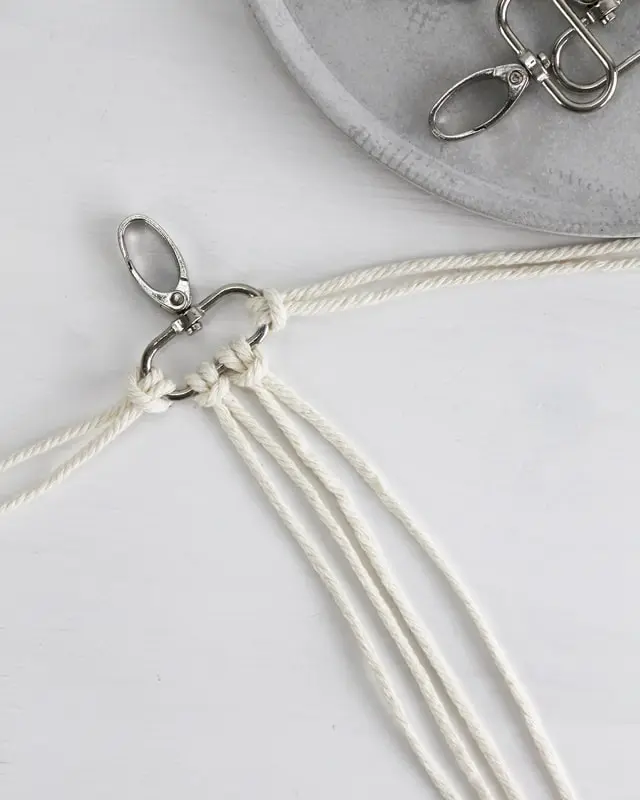 Makramee ist weiterhin im Trend und neben den klassischen Wandbehängen gibt es viele weitere Anwendungsmöglichkeiten. Im letzten Jahr habe ich mir sogar eine eigene Handtasche geknüpft. Vor ein paar Wochen bin ich nach Paris gereist und dafür brauchte ich eine kleine Umhängetasche, die ich gut vorne tragen kann. Parallel knüpfte ich an einem anderen Makrameeprojekt: einem Makramee-Übertopf mit dickerem Makrameegarn. Dabei kam mir die Idee, dass ein DIY Makramee Schultergurt aus diesem dicken Makrameegarn sicherlich toll aussähe. Also habe ich mich auf die Suche nach einer passenden Umhängetasche begeben, bei der ich den Schultergurt einfach abmachen kann, um später meinen eigenen Makramee Schultergurt daran zu befestigen. So kann man die Schultergurte beliebig wechseln. DIY Makramee Schultergurt knüpfen - 4 Anleitungen - diy makramee schultergurt handtasche knuepfen 4