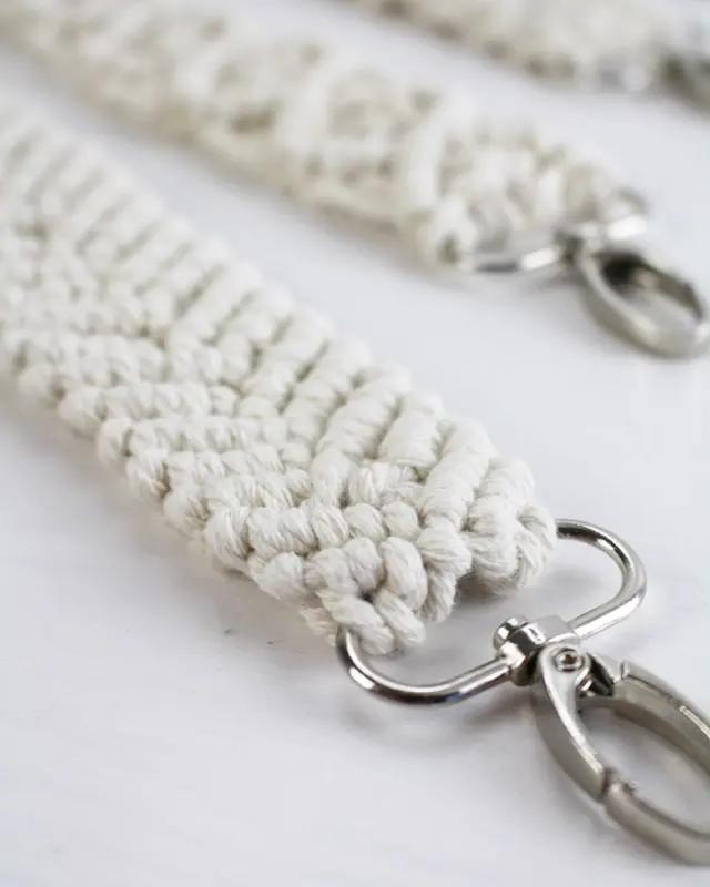 Makramee ist weiterhin im Trend und neben den klassischen Wandbehängen gibt es viele weitere Anwendungsmöglichkeiten. Im letzten Jahr habe ich mir sogar eine eigene Handtasche geknüpft. Vor ein paar Wochen bin ich nach Paris gereist und dafür brauchte ich eine kleine Umhängetasche, die ich gut vorne tragen kann. Parallel knüpfte ich an einem anderen Makrameeprojekt: einem Makramee-Übertopf mit dickerem Makrameegarn. Dabei kam mir die Idee, dass ein DIY Makramee Schultergurt aus diesem dicken Makrameegarn sicherlich toll aussähe. Also habe ich mich auf die Suche nach einer passenden Umhängetasche begeben, bei der ich den Schultergurt einfach abmachen kann, um später meinen eigenen Makramee Schultergurt daran zu befestigen. So kann man die Schultergurte beliebig wechseln. DIY Makramee Schultergurt knüpfen - 4 Anleitungen - diy makramee schultergurt handtasche knuepfen 41