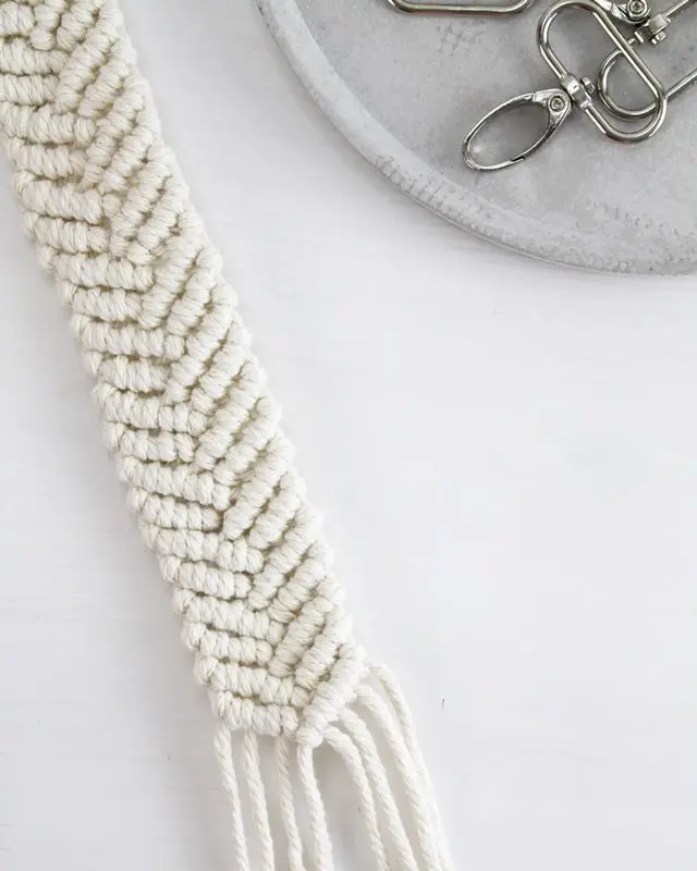 Makramee ist weiterhin im Trend und neben den klassischen Wandbehängen gibt es viele weitere Anwendungsmöglichkeiten. Im letzten Jahr habe ich mir sogar eine eigene Handtasche geknüpft. Vor ein paar Wochen bin ich nach Paris gereist und dafür brauchte ich eine kleine Umhängetasche, die ich gut vorne tragen kann. Parallel knüpfte ich an einem anderen Makrameeprojekt: einem Makramee-Übertopf mit dickerem Makrameegarn. Dabei kam mir die Idee, dass ein DIY Makramee Schultergurt aus diesem dicken Makrameegarn sicherlich toll aussähe. Also habe ich mich auf die Suche nach einer passenden Umhängetasche begeben, bei der ich den Schultergurt einfach abmachen kann, um später meinen eigenen Makramee Schultergurt daran zu befestigen. So kann man die Schultergurte beliebig wechseln. DIY Makramee Schultergurt knüpfen - 4 Anleitungen - diy makramee schultergurt handtasche knuepfen 49