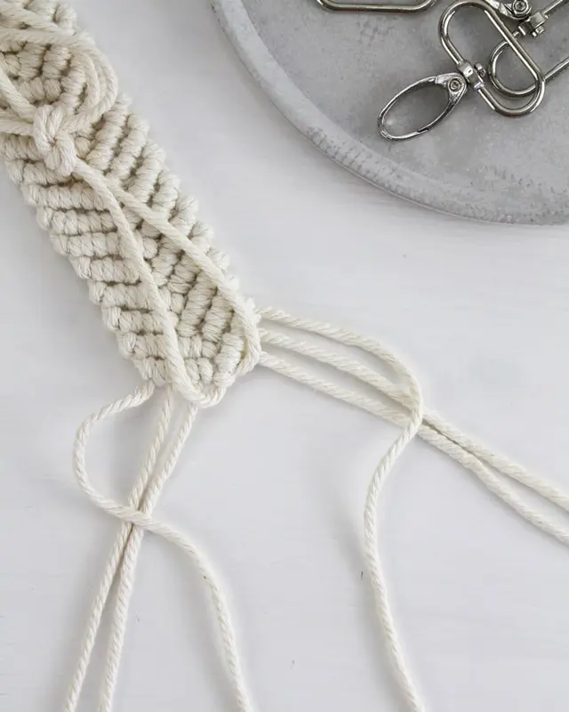 Makramee ist weiterhin im Trend und neben den klassischen Wandbehängen gibt es viele weitere Anwendungsmöglichkeiten. Im letzten Jahr habe ich mir sogar eine eigene Handtasche geknüpft. Vor ein paar Wochen bin ich nach Paris gereist und dafür brauchte ich eine kleine Umhängetasche, die ich gut vorne tragen kann. Parallel knüpfte ich an einem anderen Makrameeprojekt: einem Makramee-Übertopf mit dickerem Makrameegarn. Dabei kam mir die Idee, dass ein DIY Makramee Schultergurt aus diesem dicken Makrameegarn sicherlich toll aussähe. Also habe ich mich auf die Suche nach einer passenden Umhängetasche begeben, bei der ich den Schultergurt einfach abmachen kann, um später meinen eigenen Makramee Schultergurt daran zu befestigen. So kann man die Schultergurte beliebig wechseln. DIY Makramee Schultergurt knüpfen - 4 Anleitungen - diy makramee schultergurt handtasche knuepfen 50