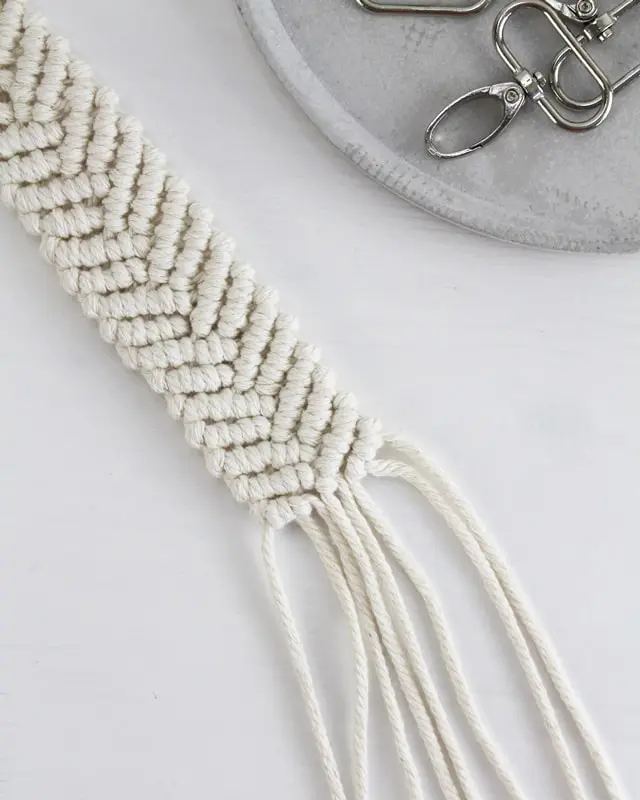 Makramee ist weiterhin im Trend und neben den klassischen Wandbehängen gibt es viele weitere Anwendungsmöglichkeiten. Im letzten Jahr habe ich mir sogar eine eigene Handtasche geknüpft. Vor ein paar Wochen bin ich nach Paris gereist und dafür brauchte ich eine kleine Umhängetasche, die ich gut vorne tragen kann. Parallel knüpfte ich an einem anderen Makrameeprojekt: einem Makramee-Übertopf mit dickerem Makrameegarn. Dabei kam mir die Idee, dass ein DIY Makramee Schultergurt aus diesem dicken Makrameegarn sicherlich toll aussähe. Also habe ich mich auf die Suche nach einer passenden Umhängetasche begeben, bei der ich den Schultergurt einfach abmachen kann, um später meinen eigenen Makramee Schultergurt daran zu befestigen. So kann man die Schultergurte beliebig wechseln. DIY Makramee Schultergurt knüpfen - 4 Anleitungen - diy makramee schultergurt handtasche knuepfen 51