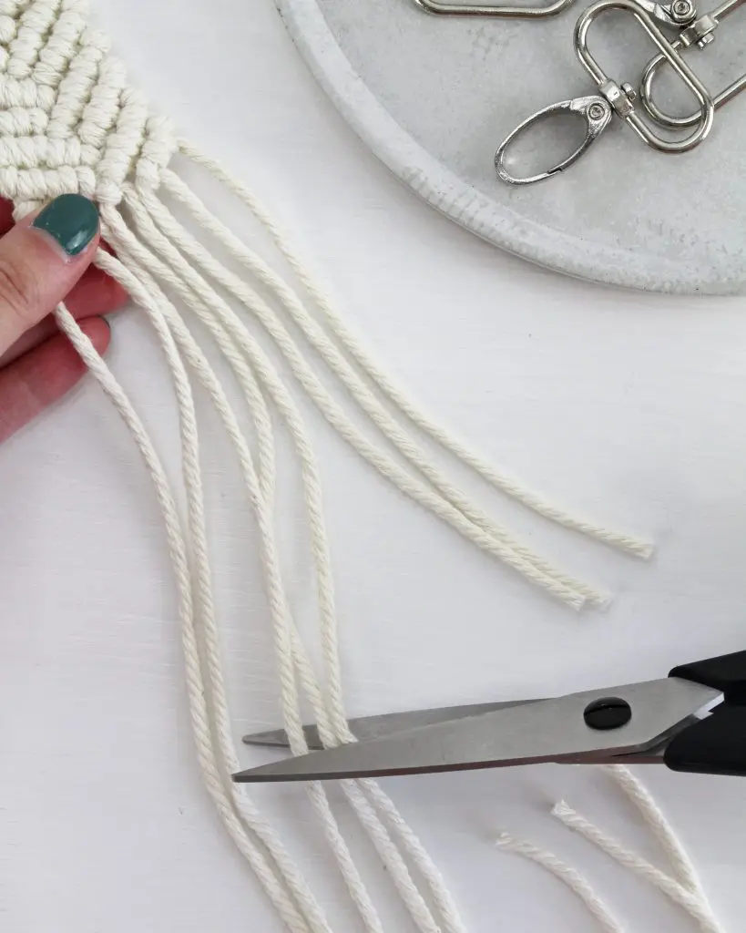 Makramee ist weiterhin im Trend und neben den klassischen Wandbehängen gibt es viele weitere Anwendungsmöglichkeiten. Im letzten Jahr habe ich mir sogar eine eigene Handtasche geknüpft. Vor ein paar Wochen bin ich nach Paris gereist und dafür brauchte ich eine kleine Umhängetasche, die ich gut vorne tragen kann. Parallel knüpfte ich an einem anderen Makrameeprojekt: einem Makramee-Übertopf mit dickerem Makrameegarn. Dabei kam mir die Idee, dass ein DIY Makramee Schultergurt aus diesem dicken Makrameegarn sicherlich toll aussähe. Also habe ich mich auf die Suche nach einer passenden Umhängetasche begeben, bei der ich den Schultergurt einfach abmachen kann, um später meinen eigenen Makramee Schultergurt daran zu befestigen. So kann man die Schultergurte beliebig wechseln. DIY Makramee Schultergurt knüpfen - 4 Anleitungen - diy makramee schultergurt handtasche knuepfen 52