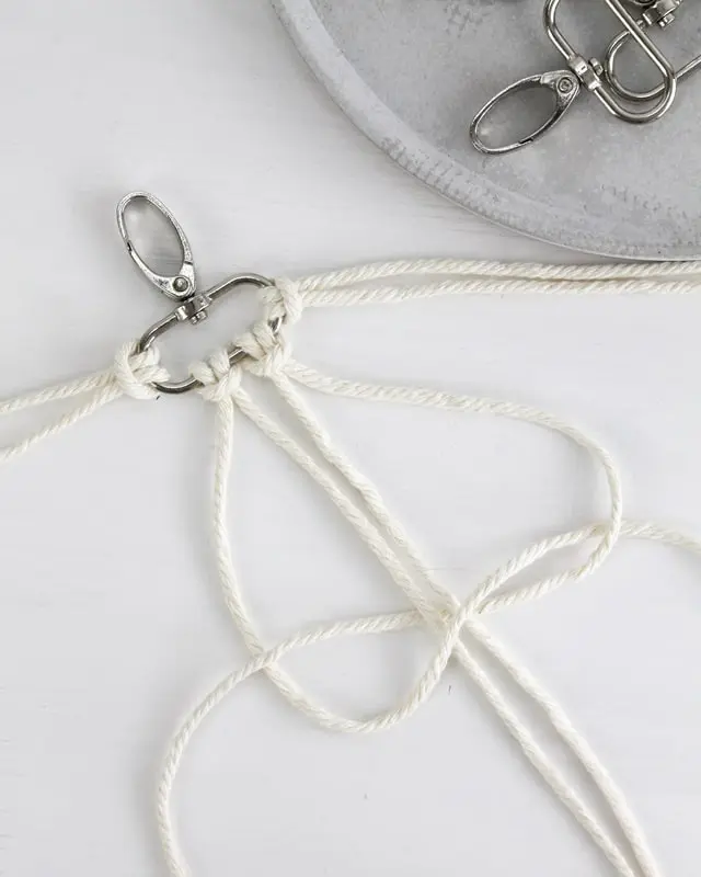 Makramee ist weiterhin im Trend und neben den klassischen Wandbehängen gibt es viele weitere Anwendungsmöglichkeiten. Im letzten Jahr habe ich mir sogar eine eigene Handtasche geknüpft. Vor ein paar Wochen bin ich nach Paris gereist und dafür brauchte ich eine kleine Umhängetasche, die ich gut vorne tragen kann. Parallel knüpfte ich an einem anderen Makrameeprojekt: einem Makramee-Übertopf mit dickerem Makrameegarn. Dabei kam mir die Idee, dass ein DIY Makramee Schultergurt aus diesem dicken Makrameegarn sicherlich toll aussähe. Also habe ich mich auf die Suche nach einer passenden Umhängetasche begeben, bei der ich den Schultergurt einfach abmachen kann, um später meinen eigenen Makramee Schultergurt daran zu befestigen. So kann man die Schultergurte beliebig wechseln. DIY Makramee Schultergurt knüpfen - 4 Anleitungen - diy makramee schultergurt handtasche knuepfen 7