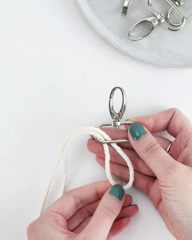 Makramee ist weiterhin im Trend und neben den klassischen Wandbehängen gibt es viele weitere Anwendungsmöglichkeiten. Im letzten Jahr habe ich mir sogar eine eigene Handtasche geknüpft. Vor ein paar Wochen bin ich nach Paris gereist und dafür brauchte ich eine kleine Umhängetasche, die ich gut vorne tragen kann. Parallel knüpfte ich an einem anderen Makrameeprojekt: einem Makramee-Übertopf mit dickerem Makrameegarn. Dabei kam mir die Idee, dass ein DIY Makramee Schultergurt aus diesem dicken Makrameegarn sicherlich toll aussähe. Also habe ich mich auf die Suche nach einer passenden Umhängetasche begeben, bei der ich den Schultergurt einfach abmachen kann, um später meinen eigenen Makramee Schultergurt daran zu befestigen. So kann man die Schultergurte beliebig wechseln. DIY Makramee Schultergurt knüpfen - 4 Anleitungen - diy makramee schultergurt handtasche knuepfen ankerknoten 1