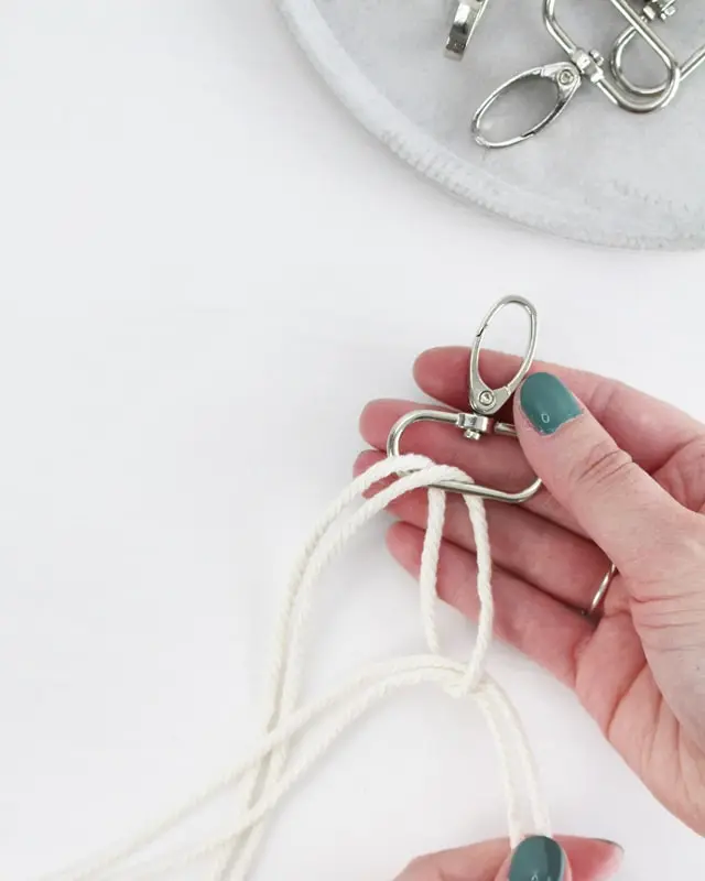 Makramee ist weiterhin im Trend und neben den klassischen Wandbehängen gibt es viele weitere Anwendungsmöglichkeiten. Im letzten Jahr habe ich mir sogar eine eigene Handtasche geknüpft. Vor ein paar Wochen bin ich nach Paris gereist und dafür brauchte ich eine kleine Umhängetasche, die ich gut vorne tragen kann. Parallel knüpfte ich an einem anderen Makrameeprojekt: einem Makramee-Übertopf mit dickerem Makrameegarn. Dabei kam mir die Idee, dass ein DIY Makramee Schultergurt aus diesem dicken Makrameegarn sicherlich toll aussähe. Also habe ich mich auf die Suche nach einer passenden Umhängetasche begeben, bei der ich den Schultergurt einfach abmachen kann, um später meinen eigenen Makramee Schultergurt daran zu befestigen. So kann man die Schultergurte beliebig wechseln. DIY Makramee Schultergurt knüpfen - 4 Anleitungen - diy makramee schultergurt handtasche knuepfen ankerknoten 2