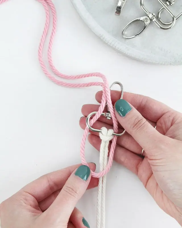 Makramee ist weiterhin im Trend und neben den klassischen Wandbehängen gibt es viele weitere Anwendungsmöglichkeiten. Im letzten Jahr habe ich mir sogar eine eigene Handtasche geknüpft. Vor ein paar Wochen bin ich nach Paris gereist und dafür brauchte ich eine kleine Umhängetasche, die ich gut vorne tragen kann. Parallel knüpfte ich an einem anderen Makrameeprojekt: einem Makramee-Übertopf mit dickerem Makrameegarn. Dabei kam mir die Idee, dass ein DIY Makramee Schultergurt aus diesem dicken Makrameegarn sicherlich toll aussähe. Also habe ich mich auf die Suche nach einer passenden Umhängetasche begeben, bei der ich den Schultergurt einfach abmachen kann, um später meinen eigenen Makramee Schultergurt daran zu befestigen. So kann man die Schultergurte beliebig wechseln. DIY Makramee Schultergurt knüpfen - 4 Anleitungen - diy makramee schultergurt handtasche knuepfen ankerknoten 4