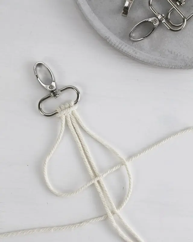 Makramee ist weiterhin im Trend und neben den klassischen Wandbehängen gibt es viele weitere Anwendungsmöglichkeiten. Im letzten Jahr habe ich mir sogar eine eigene Handtasche geknüpft. Vor ein paar Wochen bin ich nach Paris gereist und dafür brauchte ich eine kleine Umhängetasche, die ich gut vorne tragen kann. Parallel knüpfte ich an einem anderen Makrameeprojekt: einem Makramee-Übertopf mit dickerem Makrameegarn. Dabei kam mir die Idee, dass ein DIY Makramee Schultergurt aus diesem dicken Makrameegarn sicherlich toll aussähe. Also habe ich mich auf die Suche nach einer passenden Umhängetasche begeben, bei der ich den Schultergurt einfach abmachen kann, um später meinen eigenen Makramee Schultergurt daran zu befestigen. So kann man die Schultergurte beliebig wechseln. DIY Makramee Schultergurt knüpfen - 4 Anleitungen - diy makramee schultergurt handtasche knuepfen kreuzknoten 28