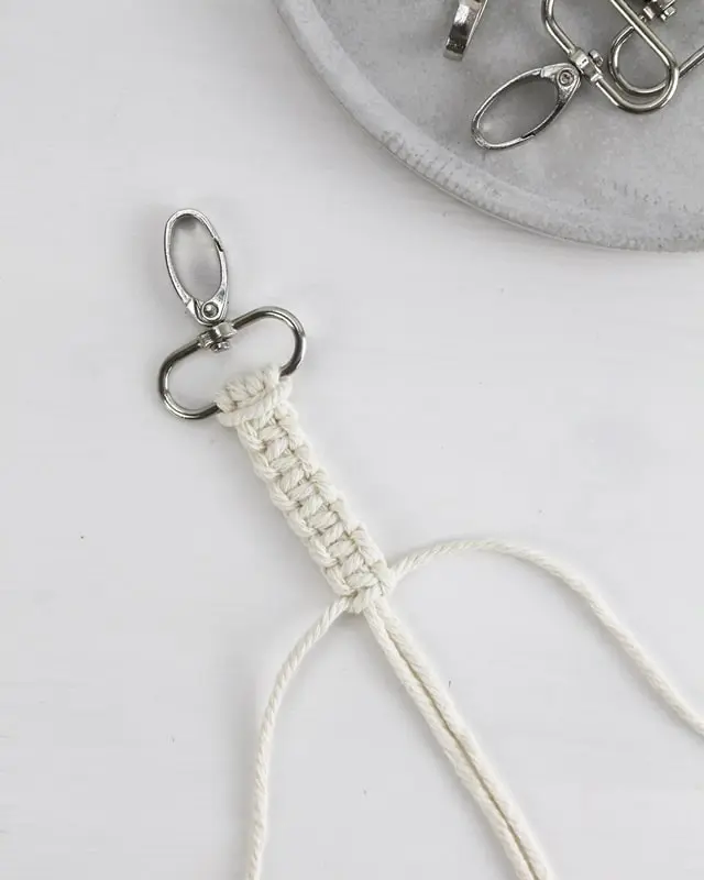 Makramee ist weiterhin im Trend und neben den klassischen Wandbehängen gibt es viele weitere Anwendungsmöglichkeiten. Im letzten Jahr habe ich mir sogar eine eigene Handtasche geknüpft. Vor ein paar Wochen bin ich nach Paris gereist und dafür brauchte ich eine kleine Umhängetasche, die ich gut vorne tragen kann. Parallel knüpfte ich an einem anderen Makrameeprojekt: einem Makramee-Übertopf mit dickerem Makrameegarn. Dabei kam mir die Idee, dass ein DIY Makramee Schultergurt aus diesem dicken Makrameegarn sicherlich toll aussähe. Also habe ich mich auf die Suche nach einer passenden Umhängetasche begeben, bei der ich den Schultergurt einfach abmachen kann, um später meinen eigenen Makramee Schultergurt daran zu befestigen. So kann man die Schultergurte beliebig wechseln. DIY Makramee Schultergurt knüpfen - 4 Anleitungen - diy makramee schultergurt handtasche knuepfen kreuzknoten 35