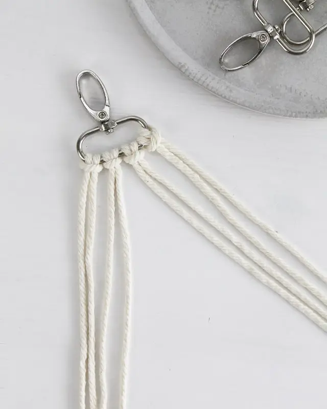 Makramee ist weiterhin im Trend und neben den klassischen Wandbehängen gibt es viele weitere Anwendungsmöglichkeiten. Im letzten Jahr habe ich mir sogar eine eigene Handtasche geknüpft. Vor ein paar Wochen bin ich nach Paris gereist und dafür brauchte ich eine kleine Umhängetasche, die ich gut vorne tragen kann. Parallel knüpfte ich an einem anderen Makrameeprojekt: einem Makramee-Übertopf mit dickerem Makrameegarn. Dabei kam mir die Idee, dass ein DIY Makramee Schultergurt aus diesem dicken Makrameegarn sicherlich toll aussähe. Also habe ich mich auf die Suche nach einer passenden Umhängetasche begeben, bei der ich den Schultergurt einfach abmachen kann, um später meinen eigenen Makramee Schultergurt daran zu befestigen. So kann man die Schultergurte beliebig wechseln. DIY Makramee Schultergurt knüpfen - 4 Anleitungen - diy makramee schultergurt handtasche knuepfen rippenknoten 1