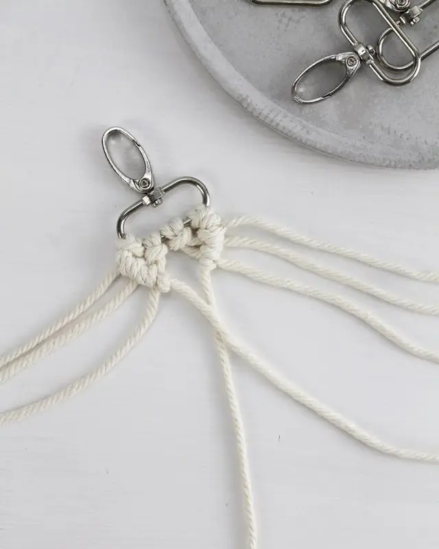 Makramee ist weiterhin im Trend und neben den klassischen Wandbehängen gibt es viele weitere Anwendungsmöglichkeiten. Im letzten Jahr habe ich mir sogar eine eigene Handtasche geknüpft. Vor ein paar Wochen bin ich nach Paris gereist und dafür brauchte ich eine kleine Umhängetasche, die ich gut vorne tragen kann. Parallel knüpfte ich an einem anderen Makrameeprojekt: einem Makramee-Übertopf mit dickerem Makrameegarn. Dabei kam mir die Idee, dass ein DIY Makramee Schultergurt aus diesem dicken Makrameegarn sicherlich toll aussähe. Also habe ich mich auf die Suche nach einer passenden Umhängetasche begeben, bei der ich den Schultergurt einfach abmachen kann, um später meinen eigenen Makramee Schultergurt daran zu befestigen. So kann man die Schultergurte beliebig wechseln. DIY Makramee Schultergurt knüpfen - 4 Anleitungen - diy makramee schultergurt handtasche knuepfen rippenknoten 10