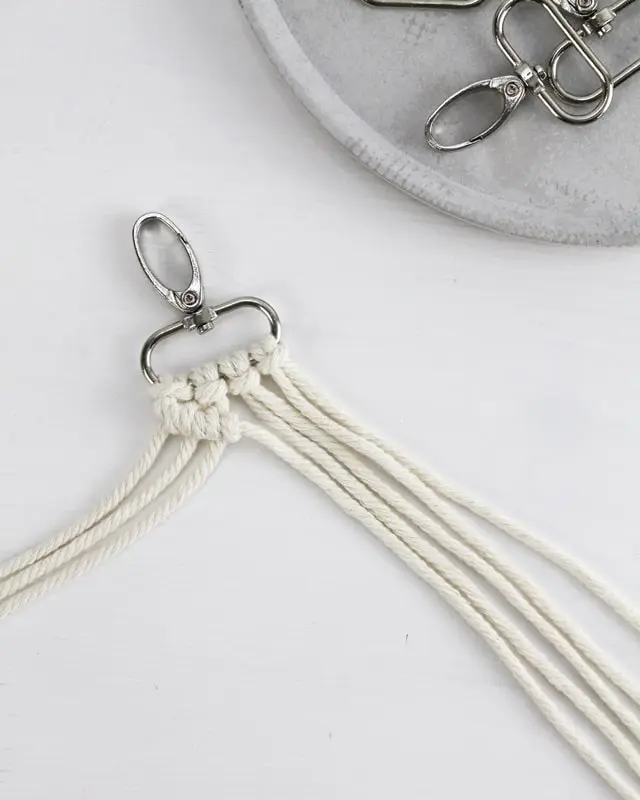 Makramee ist weiterhin im Trend und neben den klassischen Wandbehängen gibt es viele weitere Anwendungsmöglichkeiten. Im letzten Jahr habe ich mir sogar eine eigene Handtasche geknüpft. Vor ein paar Wochen bin ich nach Paris gereist und dafür brauchte ich eine kleine Umhängetasche, die ich gut vorne tragen kann. Parallel knüpfte ich an einem anderen Makrameeprojekt: einem Makramee-Übertopf mit dickerem Makrameegarn. Dabei kam mir die Idee, dass ein DIY Makramee Schultergurt aus diesem dicken Makrameegarn sicherlich toll aussähe. Also habe ich mich auf die Suche nach einer passenden Umhängetasche begeben, bei der ich den Schultergurt einfach abmachen kann, um später meinen eigenen Makramee Schultergurt daran zu befestigen. So kann man die Schultergurte beliebig wechseln. DIY Makramee Schultergurt knüpfen - 4 Anleitungen - diy makramee schultergurt handtasche knuepfen rippenknoten 2