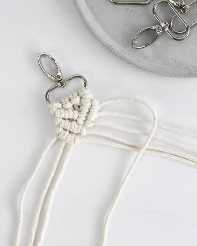 Makramee ist weiterhin im Trend und neben den klassischen Wandbehängen gibt es viele weitere Anwendungsmöglichkeiten. Im letzten Jahr habe ich mir sogar eine eigene Handtasche geknüpft. Vor ein paar Wochen bin ich nach Paris gereist und dafür brauchte ich eine kleine Umhängetasche, die ich gut vorne tragen kann. Parallel knüpfte ich an einem anderen Makrameeprojekt: einem Makramee-Übertopf mit dickerem Makrameegarn. Dabei kam mir die Idee, dass ein DIY Makramee Schultergurt aus diesem dicken Makrameegarn sicherlich toll aussähe. Also habe ich mich auf die Suche nach einer passenden Umhängetasche begeben, bei der ich den Schultergurt einfach abmachen kann, um später meinen eigenen Makramee Schultergurt daran zu befestigen. So kann man die Schultergurte beliebig wechseln. DIY Makramee Schultergurt knüpfen - 4 Anleitungen - diy makramee schultergurt handtasche knuepfen rippenknoten 24