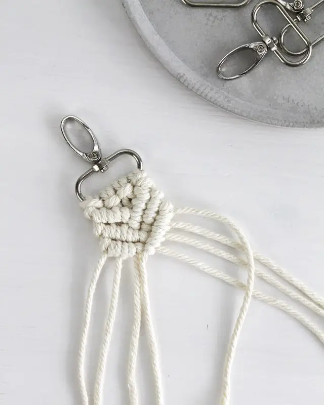 Makramee ist weiterhin im Trend und neben den klassischen Wandbehängen gibt es viele weitere Anwendungsmöglichkeiten. Im letzten Jahr habe ich mir sogar eine eigene Handtasche geknüpft. Vor ein paar Wochen bin ich nach Paris gereist und dafür brauchte ich eine kleine Umhängetasche, die ich gut vorne tragen kann. Parallel knüpfte ich an einem anderen Makrameeprojekt: einem Makramee-Übertopf mit dickerem Makrameegarn. Dabei kam mir die Idee, dass ein DIY Makramee Schultergurt aus diesem dicken Makrameegarn sicherlich toll aussähe. Also habe ich mich auf die Suche nach einer passenden Umhängetasche begeben, bei der ich den Schultergurt einfach abmachen kann, um später meinen eigenen Makramee Schultergurt daran zu befestigen. So kann man die Schultergurte beliebig wechseln. DIY Makramee Schultergurt knüpfen - 4 Anleitungen - diy makramee schultergurt handtasche knuepfen rippenknoten 26