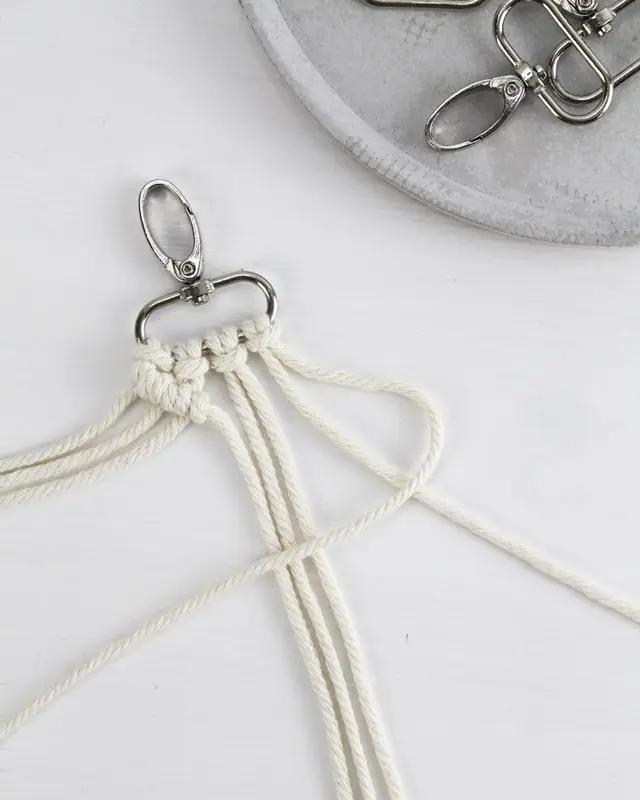 Makramee ist weiterhin im Trend und neben den klassischen Wandbehängen gibt es viele weitere Anwendungsmöglichkeiten. Im letzten Jahr habe ich mir sogar eine eigene Handtasche geknüpft. Vor ein paar Wochen bin ich nach Paris gereist und dafür brauchte ich eine kleine Umhängetasche, die ich gut vorne tragen kann. Parallel knüpfte ich an einem anderen Makrameeprojekt: einem Makramee-Übertopf mit dickerem Makrameegarn. Dabei kam mir die Idee, dass ein DIY Makramee Schultergurt aus diesem dicken Makrameegarn sicherlich toll aussähe. Also habe ich mich auf die Suche nach einer passenden Umhängetasche begeben, bei der ich den Schultergurt einfach abmachen kann, um später meinen eigenen Makramee Schultergurt daran zu befestigen. So kann man die Schultergurte beliebig wechseln. DIY Makramee Schultergurt knüpfen - 4 Anleitungen - diy makramee schultergurt handtasche knuepfen rippenknoten 3