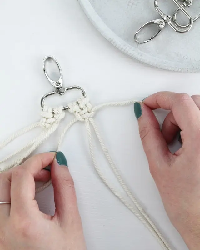 Makramee ist weiterhin im Trend und neben den klassischen Wandbehängen gibt es viele weitere Anwendungsmöglichkeiten. Im letzten Jahr habe ich mir sogar eine eigene Handtasche geknüpft. Vor ein paar Wochen bin ich nach Paris gereist und dafür brauchte ich eine kleine Umhängetasche, die ich gut vorne tragen kann. Parallel knüpfte ich an einem anderen Makrameeprojekt: einem Makramee-Übertopf mit dickerem Makrameegarn. Dabei kam mir die Idee, dass ein DIY Makramee Schultergurt aus diesem dicken Makrameegarn sicherlich toll aussähe. Also habe ich mich auf die Suche nach einer passenden Umhängetasche begeben, bei der ich den Schultergurt einfach abmachen kann, um später meinen eigenen Makramee Schultergurt daran zu befestigen. So kann man die Schultergurte beliebig wechseln. DIY Makramee Schultergurt knüpfen - 4 Anleitungen - diy schultergurt handtasche knuepfen kreuzknoten 18