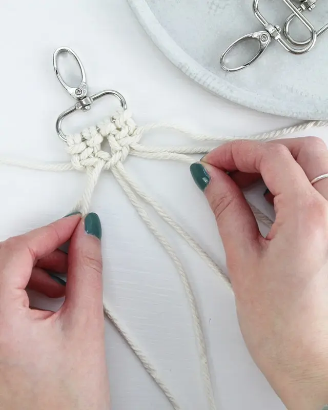 Makramee ist weiterhin im Trend und neben den klassischen Wandbehängen gibt es viele weitere Anwendungsmöglichkeiten. Im letzten Jahr habe ich mir sogar eine eigene Handtasche geknüpft. Vor ein paar Wochen bin ich nach Paris gereist und dafür brauchte ich eine kleine Umhängetasche, die ich gut vorne tragen kann. Parallel knüpfte ich an einem anderen Makrameeprojekt: einem Makramee-Übertopf mit dickerem Makrameegarn. Dabei kam mir die Idee, dass ein DIY Makramee Schultergurt aus diesem dicken Makrameegarn sicherlich toll aussähe. Also habe ich mich auf die Suche nach einer passenden Umhängetasche begeben, bei der ich den Schultergurt einfach abmachen kann, um später meinen eigenen Makramee Schultergurt daran zu befestigen. So kann man die Schultergurte beliebig wechseln. DIY Makramee Schultergurt knüpfen - 4 Anleitungen - diy schultergurt handtasche knuepfen kreuzknoten 22