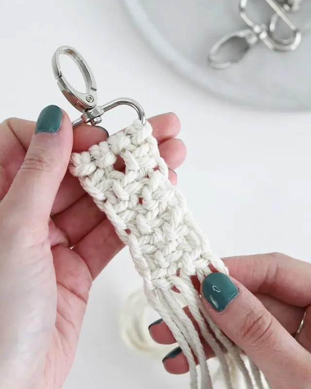 Makramee ist weiterhin im Trend und neben den klassischen Wandbehängen gibt es viele weitere Anwendungsmöglichkeiten. Im letzten Jahr habe ich mir sogar eine eigene Handtasche geknüpft. Vor ein paar Wochen bin ich nach Paris gereist und dafür brauchte ich eine kleine Umhängetasche, die ich gut vorne tragen kann. Parallel knüpfte ich an einem anderen Makrameeprojekt: einem Makramee-Übertopf mit dickerem Makrameegarn. Dabei kam mir die Idee, dass ein DIY Makramee Schultergurt aus diesem dicken Makrameegarn sicherlich toll aussähe. Also habe ich mich auf die Suche nach einer passenden Umhängetasche begeben, bei der ich den Schultergurt einfach abmachen kann, um später meinen eigenen Makramee Schultergurt daran zu befestigen. So kann man die Schultergurte beliebig wechseln. DIY Makramee Schultergurt knüpfen - 4 Anleitungen - diy schultergurt handtasche knuepfen kreuzknoten 26