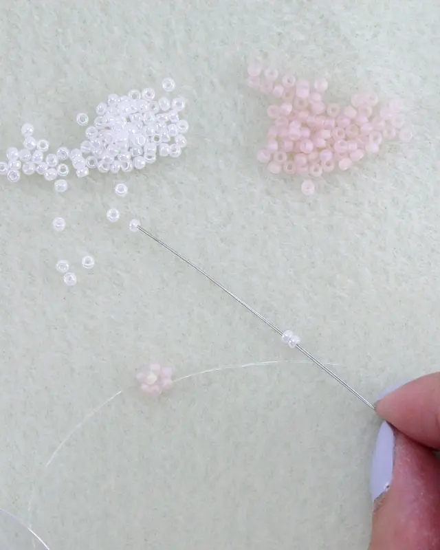 Hast du schon mal Perlenarmbänder selber gemacht? Falls nicht, keine Sorge, alle wichtigen Infos bekommst du jetzt. Von der Auswahl der Materialien bis zum fertigen Produkt - in meinem Blogbeitrag erfährst du alles, um deine eigenen DIY Perlenarmbänder zu basteln und lange Freude daran zu haben. Und falls du bereits als Kind oder auch in der letzten Zeit eigene Armbänder gebastelt hast, kannst du hier deine Kenntnisse auffrischen oder neue Muster kennenlernen. Mich hat der aktuelle Trend wieder total gefesselt und ich wünsche dir viel Spaß beim Perlenarmbänder basteln. DIY Perlenarmbänder basteln - 3 kinderleichte Ideen - diy perlen armband blume 9