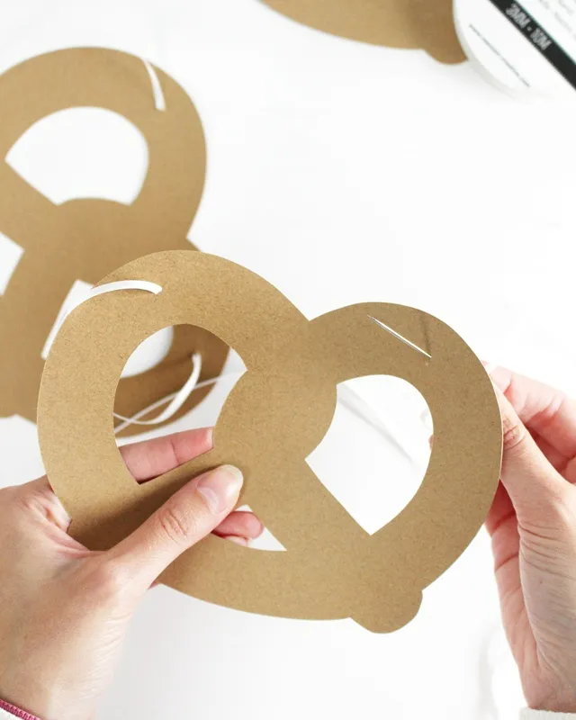 Statt kitschiger Plastikdeko kannst du deine Oktoberfest Tischdeko selber machen – rustikal, gemütlich und mit echtem Almcharakter. Viele greifen zwar schnell zu weiß-blauen Rauten und Einweg-Plastik, doch umwelttechnisch ist das kein Hit – und die Stimmung wirkt oft eher billig als festlich. DIY Oktoberfest Tischdeko - Brezelgirlande basteln | Tinkerhome - Einfache DIYs für dein Zuhause