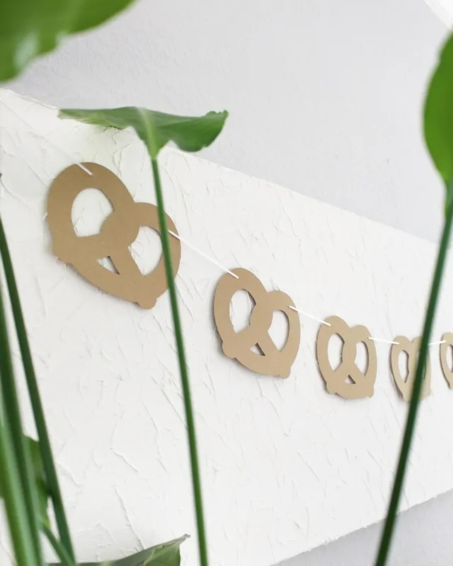 Statt kitschiger Plastikdeko kannst du deine Oktoberfest Tischdeko selber machen – rustikal, gemütlich und mit echtem Almcharakter. Viele greifen zwar schnell zu weiß-blauen Rauten und Einweg-Plastik, doch umwelttechnisch ist das kein Hit – und die Stimmung wirkt oft eher billig als festlich. Oktoberfest Tischdeko selber machen – 5 rustikale DIY Ideen im Almstil - diy brezelgirlande basteln 5