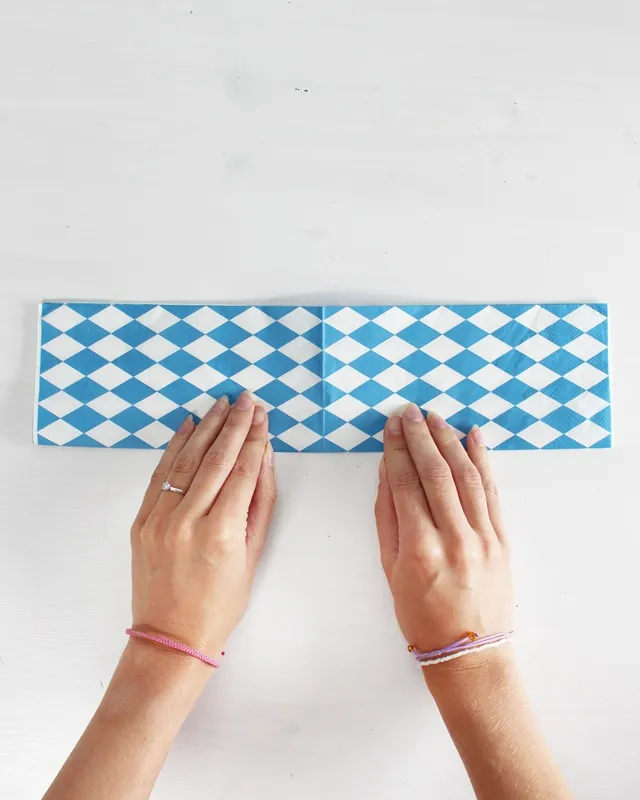 Statt kitschiger Plastikdeko kannst du deine Oktoberfest Tischdeko selber machen – rustikal, gemütlich und mit echtem Almcharakter. Viele greifen zwar schnell zu weiß-blauen Rauten und Einweg-Plastik, doch umwelttechnisch ist das kein Hit – und die Stimmung wirkt oft eher billig als festlich. Oktoberfest Tischdeko selber machen – 5 rustikale DIY Ideen im Almstil - servietten zu herzen falten 2