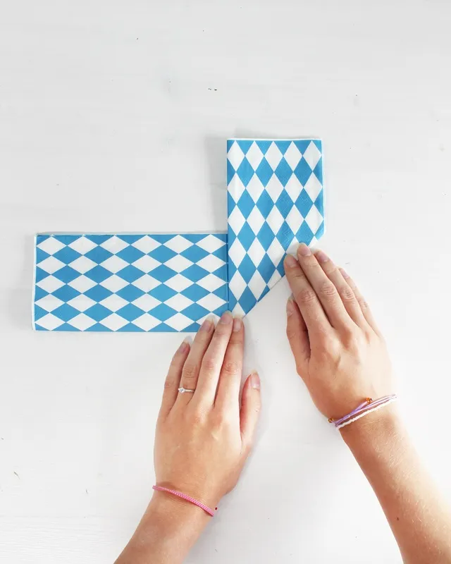 Statt kitschiger Plastikdeko kannst du deine Oktoberfest Tischdeko selber machen – rustikal, gemütlich und mit echtem Almcharakter. Viele greifen zwar schnell zu weiß-blauen Rauten und Einweg-Plastik, doch umwelttechnisch ist das kein Hit – und die Stimmung wirkt oft eher billig als festlich. Oktoberfest Tischdeko selber machen – 5 rustikale DIY Ideen im Almstil - servietten zu herzen falten 3