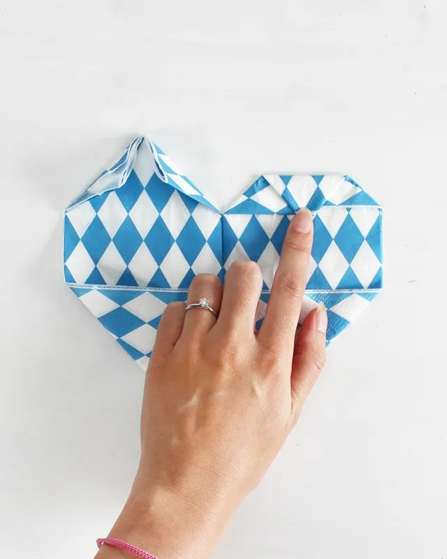 Statt kitschiger Plastikdeko kannst du deine Oktoberfest Tischdeko selber machen – rustikal, gemütlich und mit echtem Almcharakter. Viele greifen zwar schnell zu weiß-blauen Rauten und Einweg-Plastik, doch umwelttechnisch ist das kein Hit – und die Stimmung wirkt oft eher billig als festlich. Oktoberfest Tischdeko selber machen – 5 rustikale DIY Ideen im Almstil - servietten zu herzen falten 8