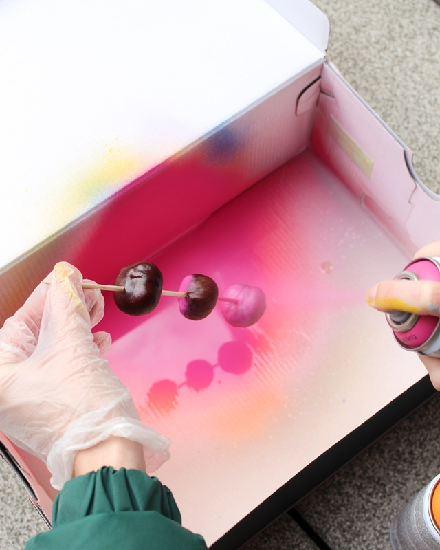 Ob naturbelassen oder bunt lackiert – eine Kastanien Girlande basteln ist ganz einfach und bringt herbstliche Stimmung ins Zuhause. Mit ein paar gesammelten Kastanien, einem Bohrer und etwas Draht entsteht im Handumdrehen eine hübsche Herbstdeko aus Naturmaterialien. Du kannst sie als Tischdeko, am Fenster oder an der Tür verwenden. Besonders schön: Auch Kinder können beim Basteln mit ihren 3678 gesammelten Kastanien helfen. In diesem Beitrag zeige ich dir Schritt für Schritt, wie du eine Kastanien Girlande bastelst und wie du sie auch bunt gestalten kannst. Kastanien Girlande basteln als Herbstdeko – Kastanien basteln mal anders - bunte kastanien girlande basteln 2