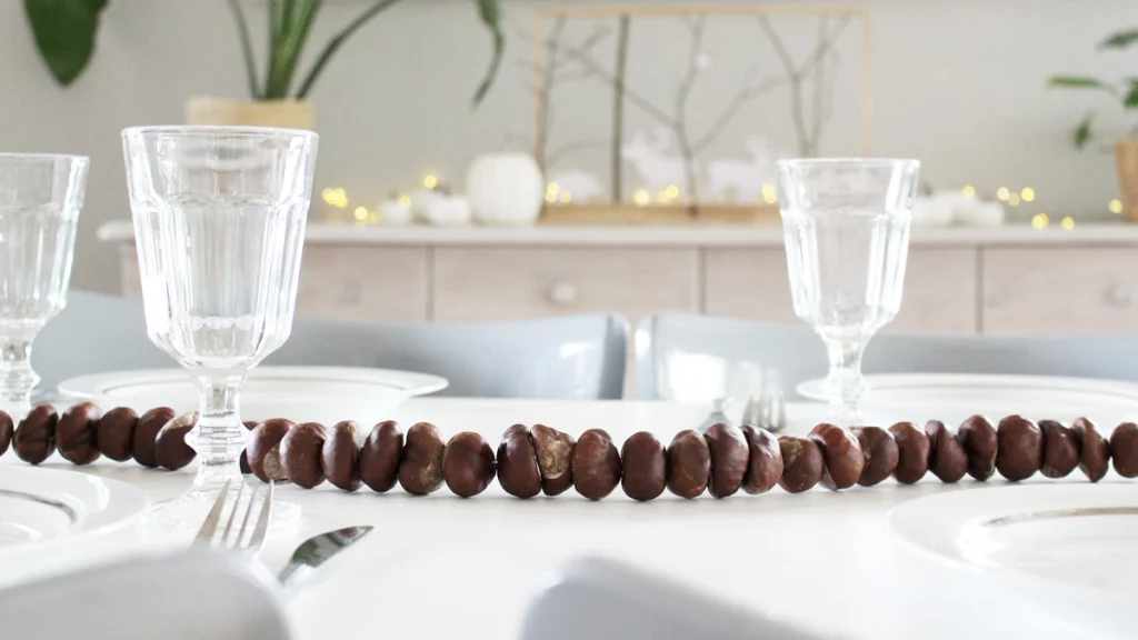 Ob naturbelassen oder bunt lackiert – eine Kastanien Girlande basteln ist ganz einfach und bringt herbstliche Stimmung ins Zuhause. Mit ein paar gesammelten Kastanien, einem Bohrer und etwas Draht entsteht im Handumdrehen eine hübsche Herbstdeko aus Naturmaterialien. Du kannst sie als Tischdeko, am Fenster oder an der Tür verwenden. Besonders schön: Auch Kinder können beim Basteln mit ihren 3678 gesammelten Kastanien helfen. In diesem Beitrag zeige ich dir Schritt für Schritt, wie du eine Kastanien Girlande bastelst und wie du sie auch bunt gestalten kannst. Kastanien Girlande basteln als Herbstdeko – Kastanien basteln mal anders | Tinkerhome - Einfache DIYs für dein Zuhause