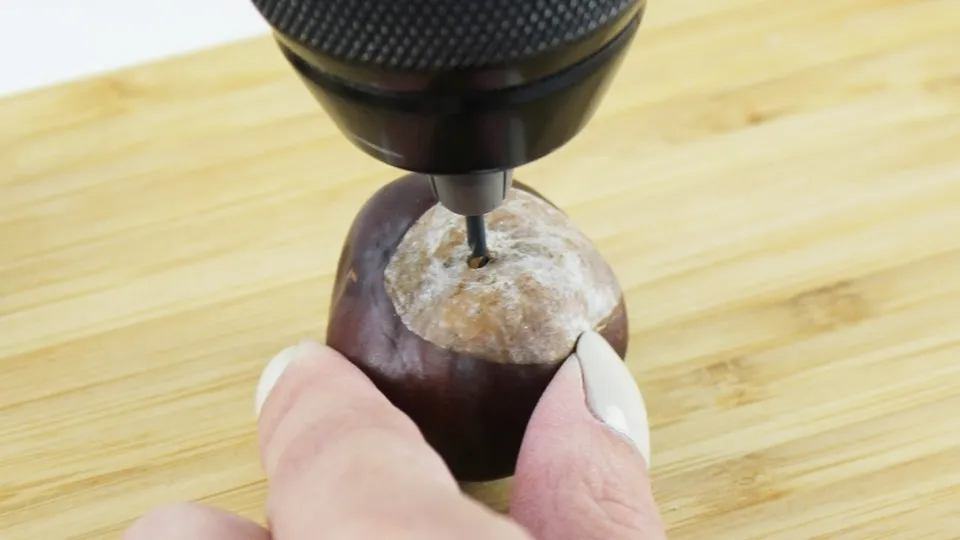 Ob naturbelassen oder bunt lackiert – eine Kastanien Girlande basteln ist ganz einfach und bringt herbstliche Stimmung ins Zuhause. Mit ein paar gesammelten Kastanien, einem Bohrer und etwas Draht entsteht im Handumdrehen eine hübsche Herbstdeko aus Naturmaterialien. Du kannst sie als Tischdeko, am Fenster oder an der Tür verwenden. Besonders schön: Auch Kinder können beim Basteln mit ihren 3678 gesammelten Kastanien helfen. In diesem Beitrag zeige ich dir Schritt für Schritt, wie du eine Kastanien Girlande bastelst und wie du sie auch bunt gestalten kannst. Kastanien Girlande basteln als Herbstdeko – Kastanien basteln mal anders - loch in kastanie bohren