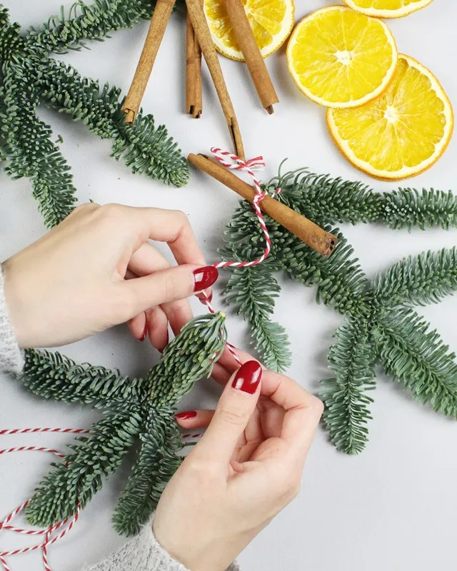 Tannengrün, selbst getrocknete Orangenscheiben, Zimtstangen und kleine Zapfen – daraus kannst du im Handumdrehen eine wunderschöne Weihnachtsgirlande basteln. In dieser Anleitung zeige ich dir Schritt für Schritt, wie du ohne viel Aufwand eine DIY Tannengirlande selber machen kannst. Ob auf dem Tisch, an der Wand oder über dem Treppengeländer – die Girlande bringt festliche Stimmung in dein Zuhause und duftet nach Weihnachten. Weihnachtsgirlande basteln: DIY Tannengirlande mit Orangenscheiben, Zimt & Zapfen - weihnachtsgirlande basteln mit tannengruen 4
