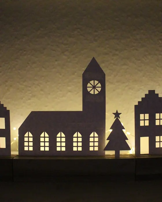 Mit der "Plotterdatei Häuser" bekommst du ein komplettes Set mit 17 winterlichen Motiven. Perfekt zum Lichterhäuser basteln, für Fensterbilder oder als aufstellbare Deko in Holzleisten. PDF-Datei + Plotterdateien (SVG + DXF) Plottervorlage Häuser - Winterdorf, Weihnachtsdorf, Lichterhäuser basteln | Tinkerhome - Einfache DIYs für dein Zuhause