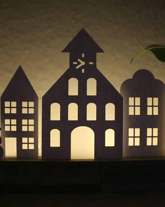 Mit der "Plotterdatei Häuser" bekommst du ein komplettes Set mit 17 winterlichen Motiven. Perfekt zum Lichterhäuser basteln, für Fensterbilder oder als aufstellbare Deko in Holzleisten. PDF-Datei + Plotterdateien (SVG + DXF) Plottervorlage Häuser - Winterdorf, Weihnachtsdorf, Lichterhäuser basteln | Tinkerhome - Einfache DIYs für dein Zuhause