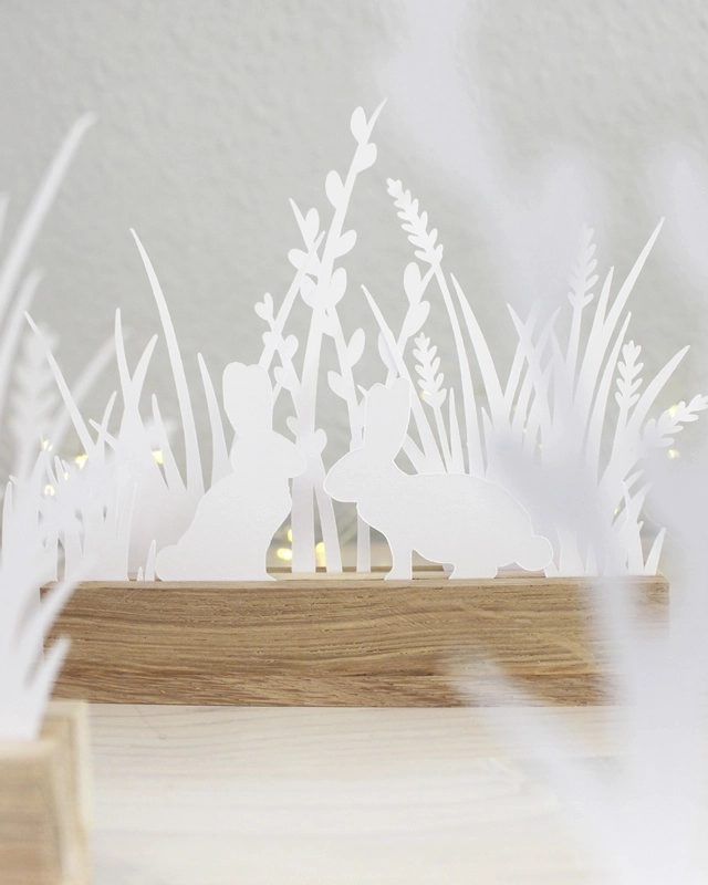 Gestalte mit der "Plotterdatei Osterwiese" eine schlichte Osterdeko aus Papier. Die minimalistischen Hasen- und Gräser-Motive können in Holzleisten oder auch als Fensterdeko genutzt werden. Plotterdateien (SVG + DXF) + PNG Plotterdatei Osterwiese - Minimalistische Osterdeko aus Papier plotten | Tinkerhome - Einfache DIYs für dein Zuhause