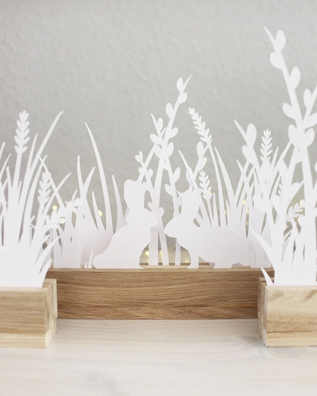 Gestalte mit der "Plotterdatei Osterwiese" eine schlichte Osterdeko aus Papier. Die minimalistischen Hasen- und Gräser-Motive können in Holzleisten oder auch als Fensterdeko genutzt werden. Plotterdateien (SVG + DXF) + PNG Plotterdatei Osterwiese aus Papier basteln | Tinkerhome - Einfache DIYs für dein Zuhause