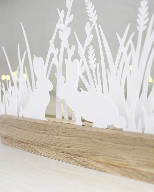 Gestalte mit der "Plotterdatei Osterwiese" eine schlichte Osterdeko aus Papier. Die minimalistischen Hasen- und Gräser-Motive können in Holzleisten oder auch als Fensterdeko genutzt werden. Plotterdateien (SVG + DXF) + PNG Plotterdatei Osterwiese aus Papier basteln | Tinkerhome - Einfache DIYs für dein Zuhause