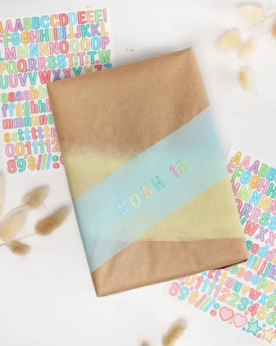 Die Einschulung steht vor der Tür und das perfekte Geschenk liegt bereit? Dann fehlt jetzt nur noch die passende Hülle! Wenn du eine Geschenkverpackung zur Einschulung basteln möchtest, die garantiert für leuchtende Augen sorgt, bist du hier genau richtig. Ich zeige dir, wie du einfaches Geschenkpapier aufpeppen oder aus ein paar Materialien eine ausgefallene Geschenkverpackung zur Einschulung basteln kannst. Geschenkverpackung zur Einschulung basteln: 3 kreative DIY-Ideen - geschenkverpackung einschulung basteln buchstabensticker 7