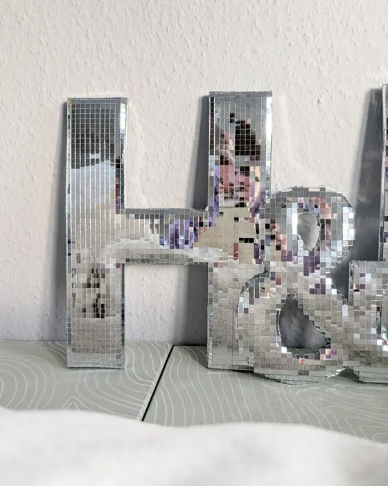 Du suchst nach einem funkelnden Highlight für die nächste Party, deine Hochzeit oder dein Zuhause? Ich zeige dir, wie du Buchstaben aus Pappe selber machen kannst und wie diese mit Spiegelmosaikfliesen in Disco Buchstaben verwandelt werden. Das Praktische ist, dass diese durch die Spiegelmosaikfliesen selbst im kleinen Format auffallen und mit etwas Luftpolsterfolie bekommen sie einen tollen 3D-Effekt, ohne dass du komplizierte 3D-Körper aus Karton basteln musst. 3D Disco Buchstaben aus Pappe selber machen: Spiegelmosaik DIY - 3D disco buchstaben basteln 13